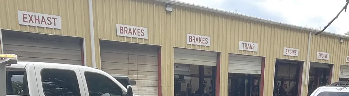 The signs over the first six bay doors: Exhaust, Brakes, Brakes, Trans, Engine, Engine